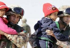 جنود أردنيون يساعدون لاجئين بدخول الأراضي الأردنية