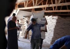 لاجئ فلسطيني يتسلم معونة غذائية من أحد مراكز الاونروا بغزة