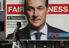 مهاجر أفريقي يمر جانب لافتة انتخابية