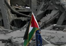 طفل يحمل علم فلسطين بغزة