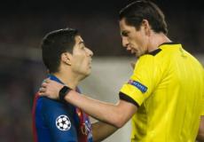  الحكم الألماني دينيز أيتكين مع لاعب برشلونة لويس سواريز