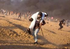 الصحفي حاتم عُمر أثناء إنقاذه لمُسن فلسطيني شرق خان يونس