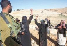 جندي اسرائيلي يقف أمام بدو فلسطينيون