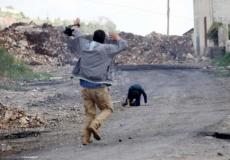 فلسطيني يحاول اسعاف طفل مصاب