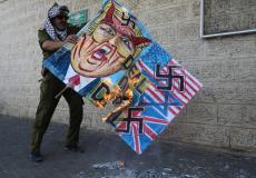 فلسطيني يحرق صور للرئيس الأمريكي دونالد ترامب في غزة 