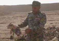 شريط فيديو يظهر عسكريا عراقيا يحمل لعبة طفل في المقبرة الجماعية 