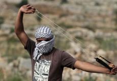 فلسطيني يلقي الحجارة 