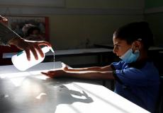 طالب فلسطيني يعقم يديه للحماية من فيروس كورونا