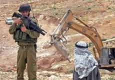 جندي يصوب سلاحه في وجه فلسطيني