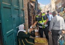 أحد أفراد الشرطة يقوم بتوزيع الكمامات على المواطنين