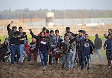 شبان ينقلون أحد الإصابات برصاص الاحتلال على حدود غزة- أرشيفية