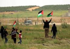 فلسطينون يرفعون العلم الفلسطيني على حدود غزة