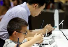 طفل ووالده في أحد متجر الهواتف الذكية.