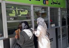 مواطنات يبدلن العملة لدى أحد محلات الصرافة في نابلس بالضفة الغربية 