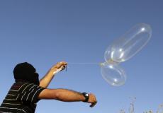 فلسطيني يطلق بالوناً حارقاً باتجاه الأراضي المحلتة