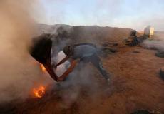 متظاهر يحاول إخماد حريق أحدثته الطائرة الإسرائيلية بعدما قذفت قنابل حارقة صوب الخيام