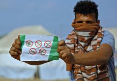 مواطن يحمل أحد المناشير التي ألقتها طائرات الاحتلال شرق غزة