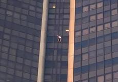 رجل يتسلق ناطحة سحاب بدون معدات أمان -صورة من الفيديو-