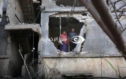 فلسطينيان يقفان على حافة منزل دمره الاحتلال في غزة