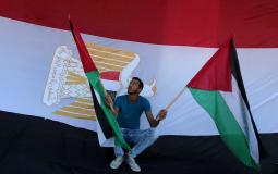فلسطيني يحمل العلمين المصري والفلسطيني