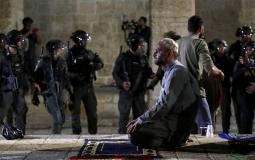فلسطيني يصلى في المسجد الأقصى بالقدس قرب جنود اسرائيليين