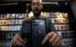 موظف من قسم التكنولوجيا في شركة سيتي فون يعرض جهاز أيفون 13 داخل معرض الشركة في مدينة غزة