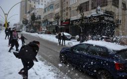أطفال يعلبون بالثلوج في مدينة الخليل