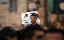 فلسطينيون يحملون صورة للأسير ناصر أبو حميد