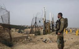 جندي إسرائيلي بالقرب من فتحة بالجدار الفاصل في الضفة