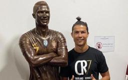 اللاعب كريستيانو رونالدو مع التمثال الخاص به