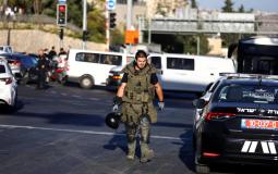جندي اسرائيلي يتفقد مكان تفجير محطة الحافلات المركزية بالقدس