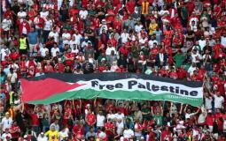 الجماهير ترفع علم فلسطين خلال مباراة تونس وأستراليا بكأس العالم في قطر (رويترز)