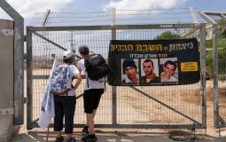 مستوطنون يقفون بجانب صور الجنود الإسرائيليون الأسرى لدى كتائب القسام