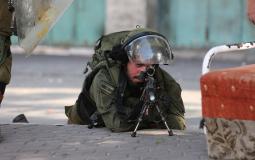 جندي إسرائيلي يصوب سلاحه على الفلسطينيين بالضفة - أرشيف