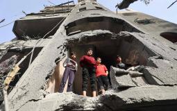 أطفال فلسطينيون يقفون داخل مبنى مدمَّر الاثنين في دير البلح وسط غزة (أ.ف.ب)