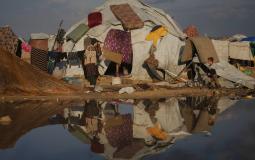 امرأة وطفل أمام خيمتهما في مخيم للنازحين على شاطئ مدينة غزة الثلاثاء (أ.ب)