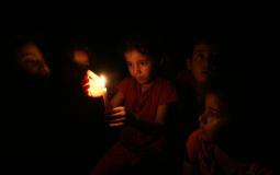 أطفال يستخدمون الشموع للإنارة في ظل انقطاع الكهرباء