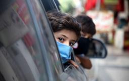 طفل يرتدى كمامة تخوفا من فيروس كورونا في غزة- APA