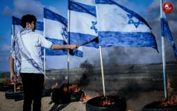 فتى فلسطيني يحرق علم دولة الاحتلال خلال مسيرات العودة الكبرى شرق غزة