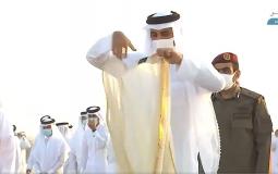 أمير قطر وهو يقلب ردائه