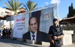 رجل أمن فلسطيني يقف أمام صورة للرئيس المصري في غزة