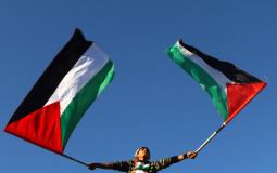 فتى فلسطيني يحمل رايات فلسطين دعما للمصالحة