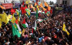 متظاهرون يرفعون أعلام فصائل فلسطينية