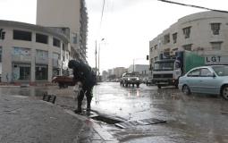 أحد طواقم بلدية غزة يقوم بتصريف مياه الأمطار 