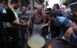مواطن يعد أكلة الجريشة لتوزيعها على الفقراء في غزة