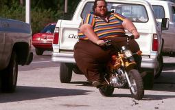 شخص سمين يسوق دراجة