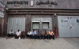 موظفون أمام بنك فلسطين في غزة