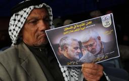 مسن يحمل صورة لقائد فيلق القدس