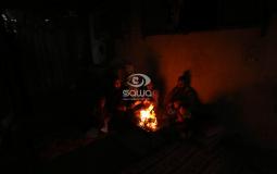فلسطيني يشعل النار للتدفئة في خانيونس