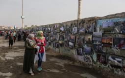 فتاتان من غزة يشهدن معرضاً للصور في ميناء غزة